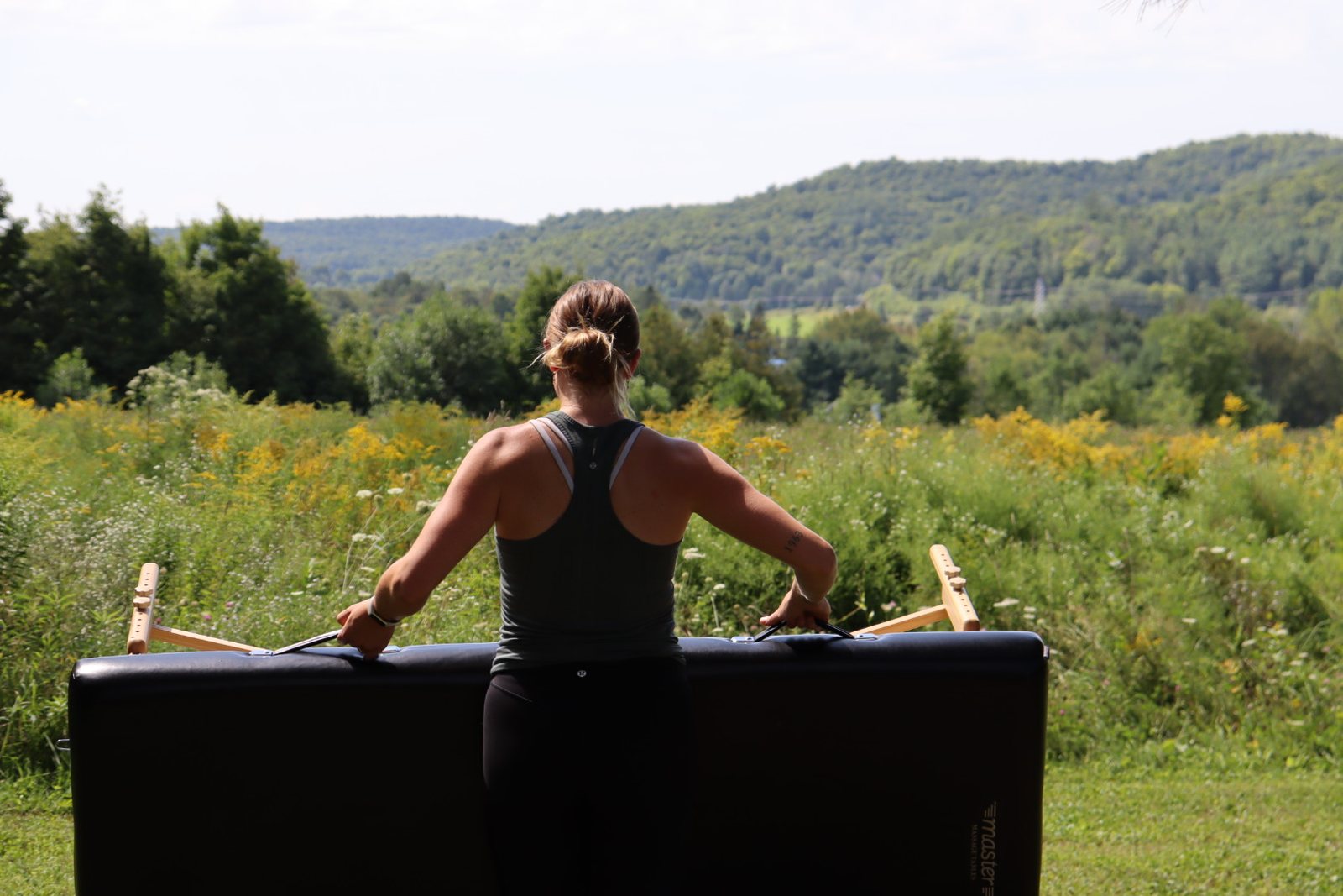 Maddie at the treatment table with the fascial stretch therapy straps, looking out over the hills.